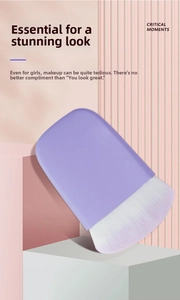 Detailed view of large flat makeup brush with purple gradient bristles and matte handle