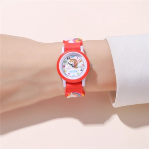 Close-up of child wearing red unicorn watch with rainbow silicone strap and white dial
