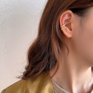 Three-piece gold ear cuff set featuring twisted texture and zircon on model ear