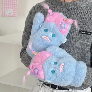 Poupée monstre en peluche bleue avec cheveux roses et pinces étoiles en main