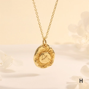 Close-up of gold coin pendant necklace with eagle sun relief and micro-zirconia inlay