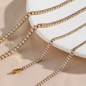 Collier chaîne tennis doré avec zircons ronds étincelants sur un plateau blanc chic