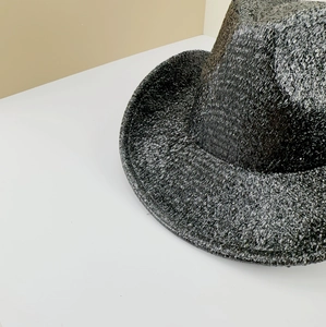 Détail macro de la texture tissée métallique brillante d'un chapeau de cowboy noir