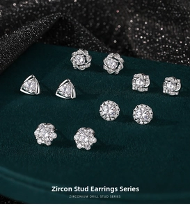 Macro shot of silver stud earrings with zirconia stones on green velvet display