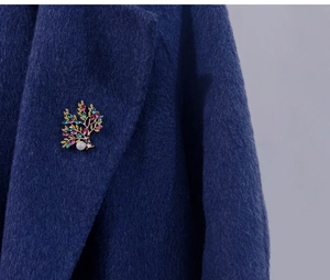 Detail of Tree of Life brooch with colorful crystals and pearl on navy wool coat