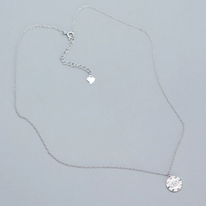 Macro shot of s925 silver devil's eye pendant necklace with colorful gems and heart charm