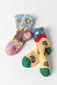 Detail of coral fleece socks with colorful cartoon house patterns and plush texture