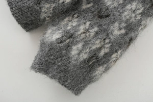 Macro shot of gray and white mottled knit fabric with brushed mohair texture and ribbed cuff