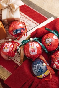 Detail of red festive socks in a creative spherical gift box with pearls and silk ribbon
