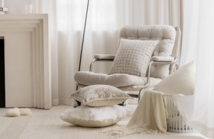 Close-up of beige luxury textured cushions and knitted blanket in a cozy living room decor