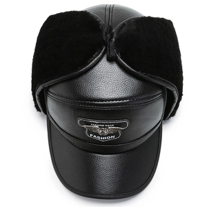Close-up of winter leather bomber hat with plush faux fur lining and metal eagle badge