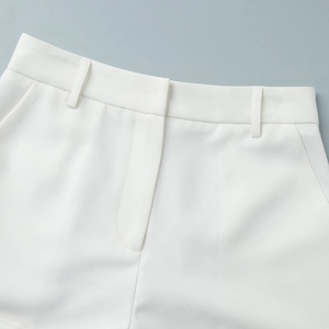 Detailed macro view of white suit shorts waist with belt loops and clean stitching