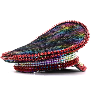 Detailed view of red metallic spikes and colorful sequins on a festival military hat