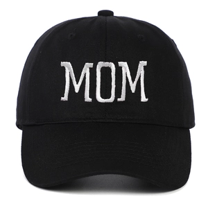 Detail of white MOM embroidery on a black cotton baseball cap with high texture contrast