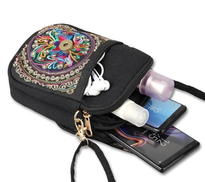 Internal view of ethnic embroidered canvas phone bag with multiple zipper compartments