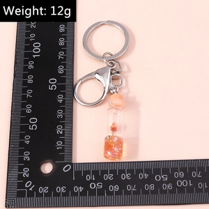 Detail view of fruit wish bottle keychain with ruler measuring about 10cm total length