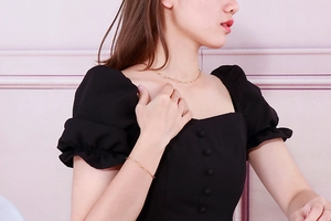 Close-up of golden paperclip link necklace and bracelet set worn on a model