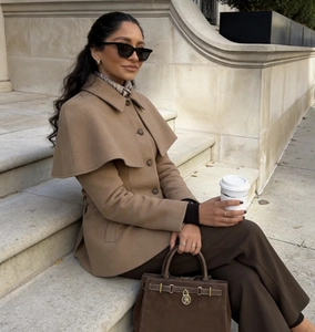 Detailed view of camel wool jacket with stylish cape collar and tailored waist design