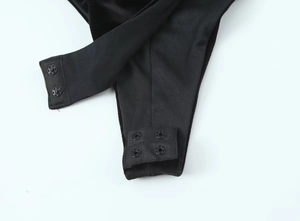 Detail view of the secure snap button closure on black velvet bodysuit for women