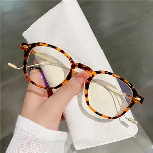 Retro tortoiseshell round glasses with gold metal temples shown on a white leather case