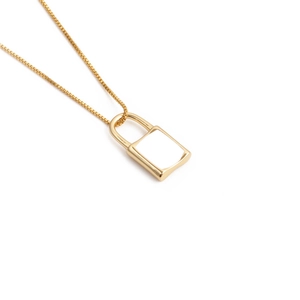 Close-up of gold-plated padlock pendant necklace with smooth enamel finish details