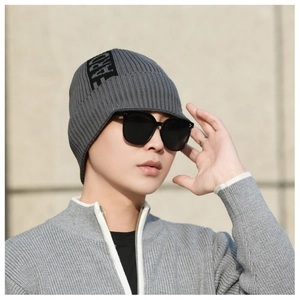 Detail of dark grey knit beanie featuring side ribbon trim and textured warm fabric
