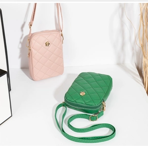 Close-up of quilted cell phone bags in pink and green with floral metal accents