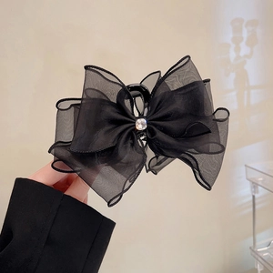 Detail of black mesh lace bow hair claw clip with a sparkling central rhinestone
