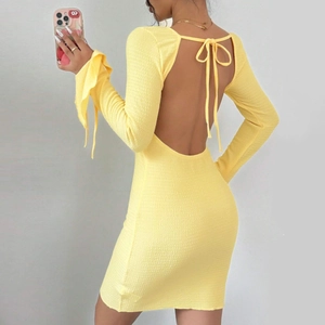 Détail d'une robe courte jaune vif dos nu avec manches longues à lacets et tissu texturé