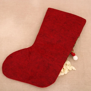 Close-up of a large red felt Christmas stocking with textured linen button detail