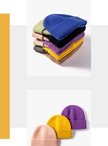 Detailed close-up of thick knit winter beanies showing textured weave and varied colors