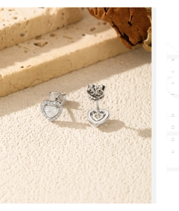 Macro detail of heart-shaped silver earrings featuring main stone and diamond halo