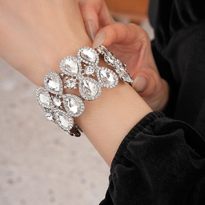 Gros plan d'un bracelet jonc argenté avec strass poire sur poignet avec fond en velours