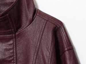 Detailed close-up of dark wine red PU leather texture and shoulder stitching on jacket