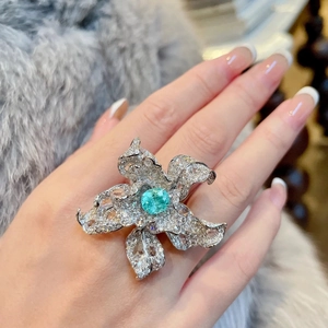 Luxurious flower ring with turquoise gemstone and crystal pavé on a fur background