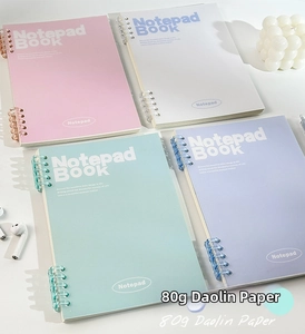 Flat lay of macaron-colored spiral notebooks with 80g Daolin paper on a desk