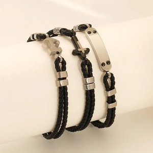 Ensemble de trois bracelets en cuir tressé noir avec breloques ancre, croix et plaque
