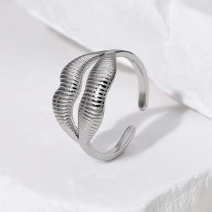 Minimalist lip-shaped titanium steel ring with textured silver finish on white stone stand