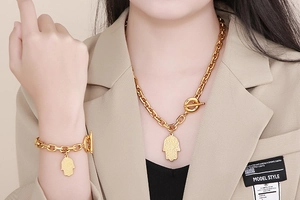 Detail of gold Hamsa hand pendant necklace and bracelet set with OT toggle closure