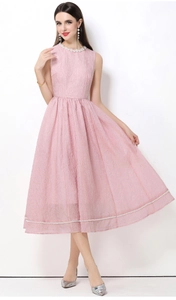 Dettaglio dell'abito smanicato rosa con eleganti perle bianche ricamate sul bordo inferiore