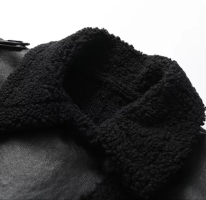 Detailed macro view of the black leather texture and fluffy faux fur collar on a winter coat