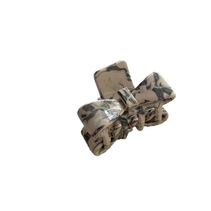 Elegant tortoiseshell bow-shaped acetate hair claw clip in creamy marble pattern for women