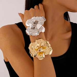Irregular flower metal cuff bracelet in gold and silver finish on model's wrist