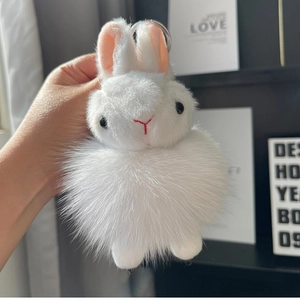 Close-up of fluffy white bunny keychain with soft fur texture and metal ring detail