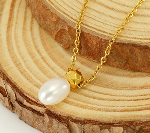 Macro shot of gold pearl necklace on wooden background highlighting detailed craft