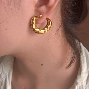 Orecchino a cerchio intrecciato in acciaio inossidabile dorato in stile vintage su modella