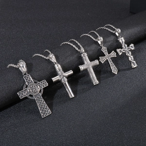Detailed macro view of five vintage silver titanium steel cross pendants on a dark background