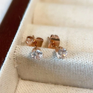 Detail of rose gold four-prong stud earrings with sparkling cubic zirconia in jewelry box