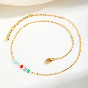 Detail of gold chain necklace featuring five vibrant multi-colored beads and lobster clasp