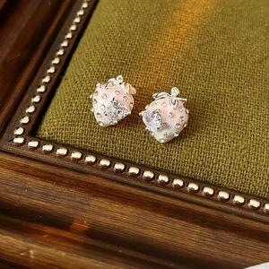 Macro shot of strawberry stud earring with pink enamel and sparkling heart zircon